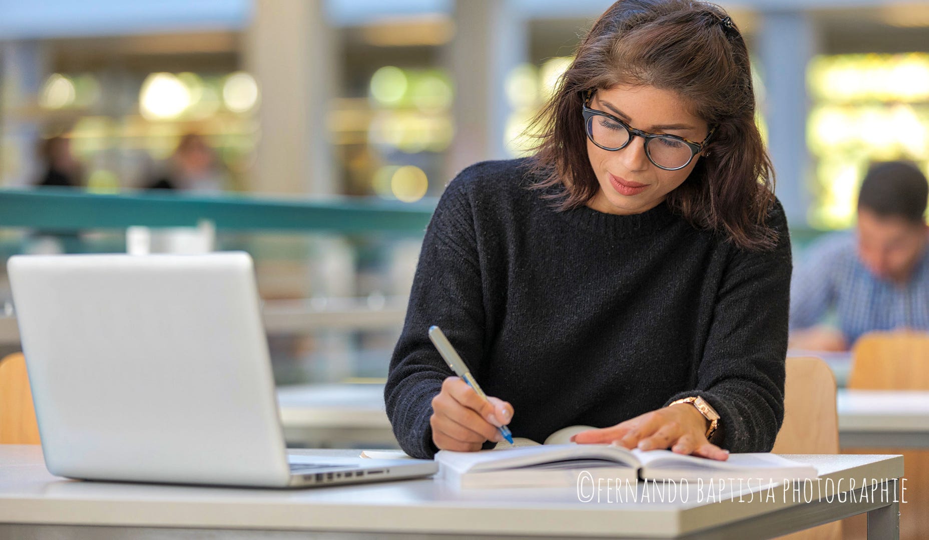 Junge Frau sitzt in der Mainzer Uni vor einem Laptop und schreibt