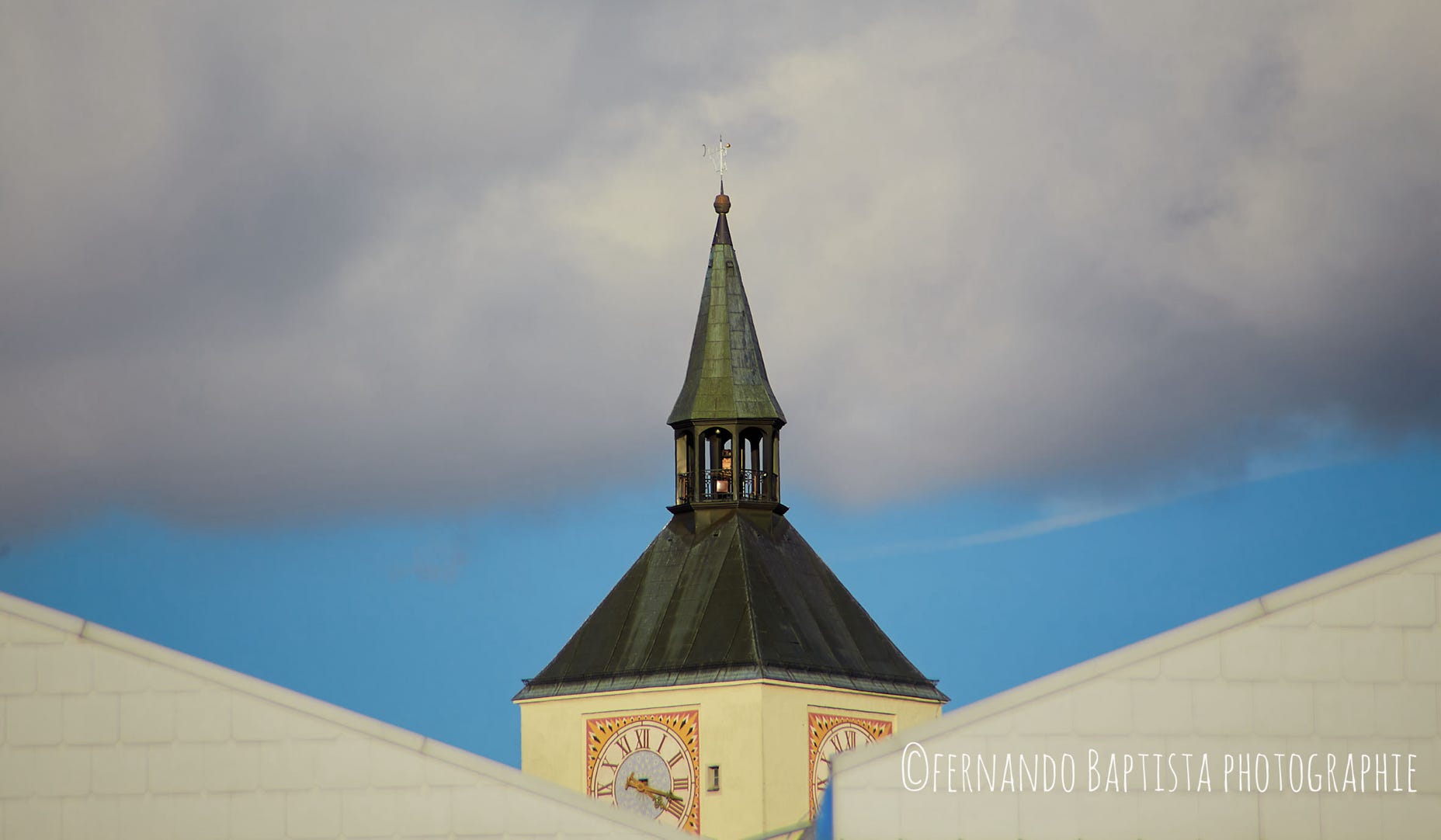 Kirchendach in der Sonne mit Wolkenhimmel